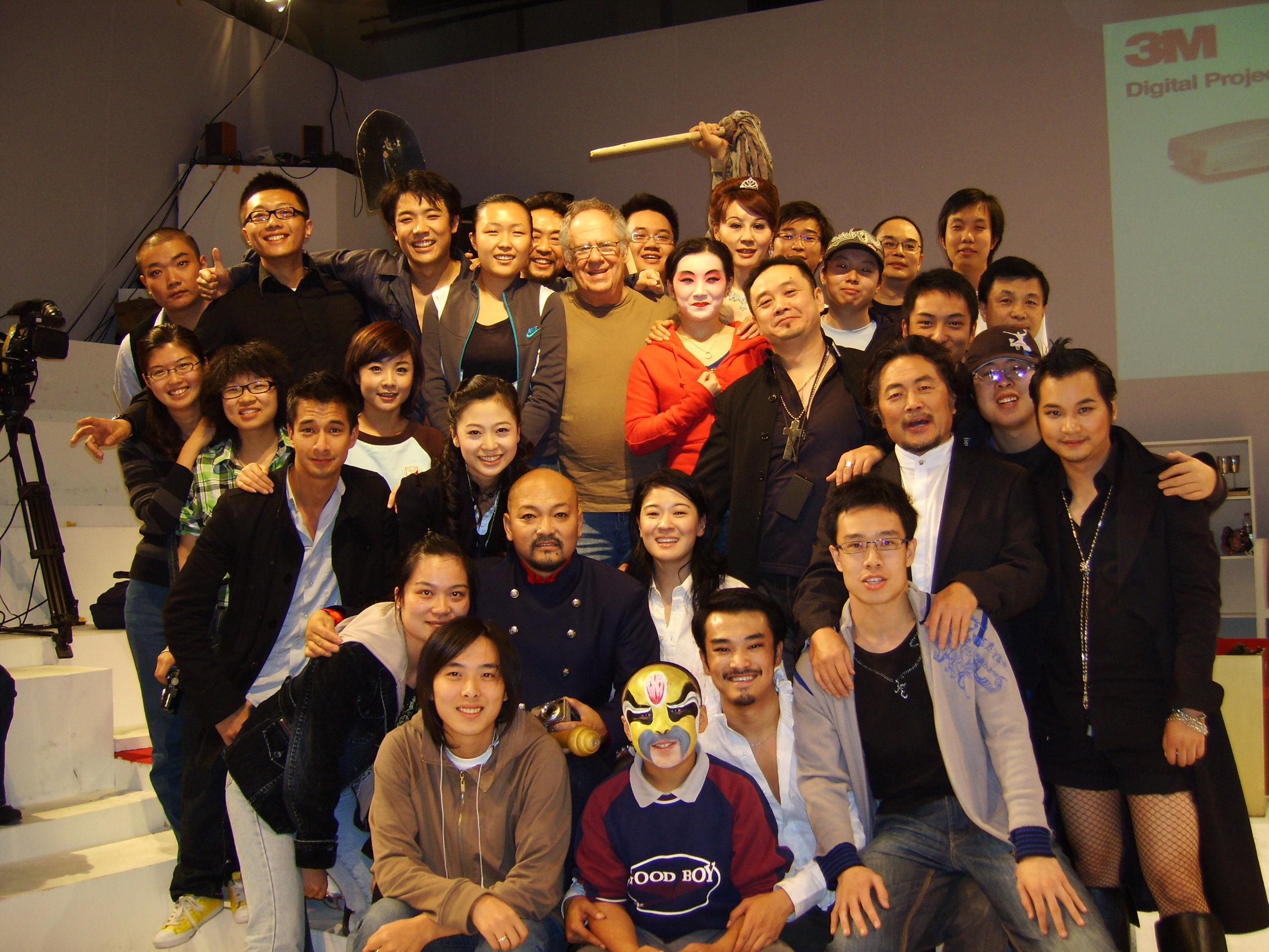 A large group of performers and collaborators posing together on a stage